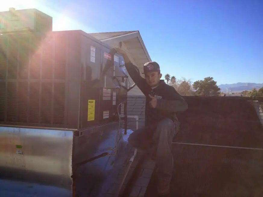 HVAC technician performing Air Duct Repair on a rooftop unit in Ellisville